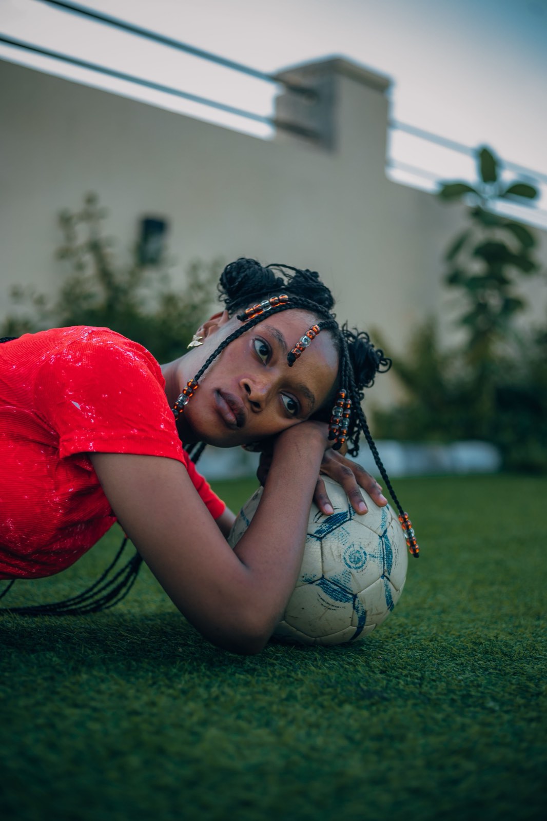 A player resting her head on a football on the turf